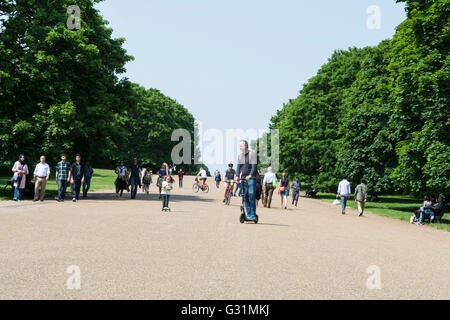 Un uomo e sua figlia in scooter a Hyde Park, City of Westminster, Londra, Inghilterra, Regno Unito Foto Stock