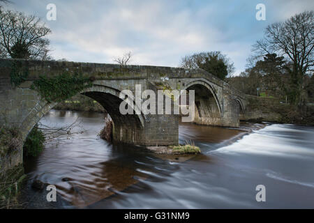 Con 2 arcate, la storica, pietra "ponte vecchio", Ilkley, West Yorkshire, Inghilterra, attraversa il fiume Wharfe - il movimento sfocati con una lunga esposizione. Foto Stock