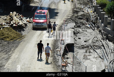 La Baviera, Germania. Il 6 giugno, 2016. Aiutanti che trasportano pale e benne a piedi lungo un fango-coperto e danneggiato street a Simbach am Inn, Germania, 06 giugno 2016. Sette persone sono morte nel paese a seguito delle inondazioni che hanno causato notevoli danni. Credito: dpa picture alliance/Alamy Live News Foto Stock