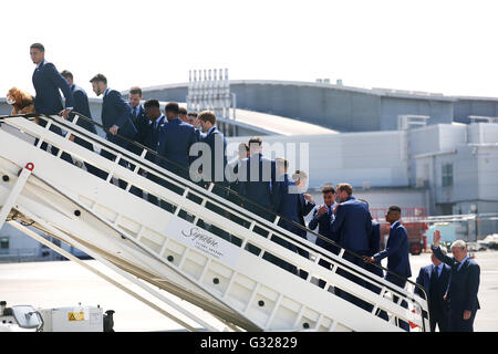 Inghilterra manager Roy Hodgson (destra) onde come il team di bordo dell'aereo all'Aeroporto di Luton. Foto Stock