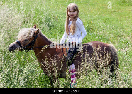 Bionda 6 anni, bambina cavallo pony bambino su pony Kid Foto Stock