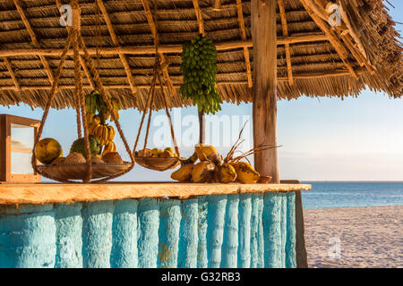 Nella foto il bar sulla spiaggia di Nungwi ( Zanzibar ) al tramonto , con esposto il cocco , banana e frutta tropicale .Questa barra è realizzata w Foto Stock