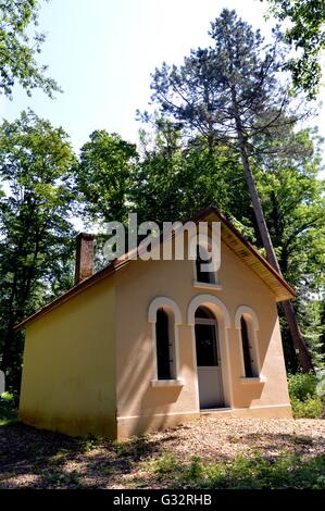 Ex cappella restaurata nella foresta con porte e finestre in arch. Foto Stock