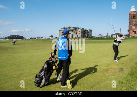 Golfista con caddie giocando al XVIII verde su Old Course a St Andrews in Fife, Scozia, Regno Unito Foto Stock