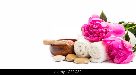Impostazione di Spa con peonie rosa, asciugamani di cotone , pietre Massaggio isolato Foto Stock