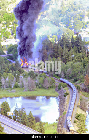 Fumo nero si riversa da accartocciata petroliere dopo una petroliera fiery treno deragliamento Giugno 3, 2016 in Mosier, Oregon. La Union Pacific treno che trasportano petrolio greggio ha saltato le piste 70 miglia ad est di Portland lungo una zona panoramica del Columbia River Gorge costringendo evacuazione della piccola città nelle vicinanze. Foto Stock