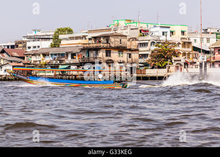 Un tipico e colorato thai barca dalla coda lunga accelerazione sul Fiume Chao Praya fiume nella città di Bangkok Foto Stock