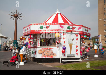 Round caramella conico Striped Novità bancarella vendendo gelati, bevande, cibi e articoli di novità per la stagione estiva i turisti e villeggianti e turisti giornalieri voce alla spiaggia del resort. Southport, Merseyside, Regno Unito. Foto Stock