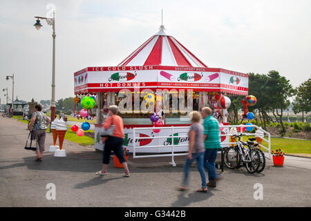 Il chiosco conico Candy Striped Novelty vende gelati, bevande, cibi e articoli di novità per i turisti estivi, i turisti e gli escursionisti che si dirigono verso la spiaggia del resort. Southport, Merseyside, Regno Unito. Foto Stock