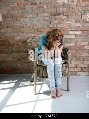 Donna seduta sulla sedia in depressione Foto Stock