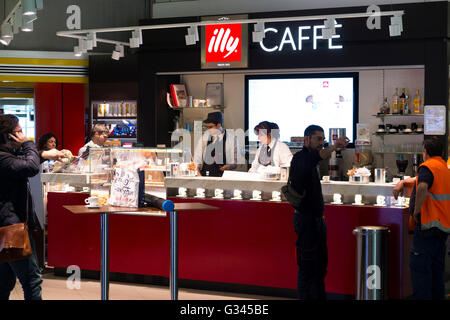 Illy caffè di marca / caffetteria Cafe che serve / è che serve bevande e spuntini per i passeggeri all'aeroporto di Milano, Italia. Foto Stock