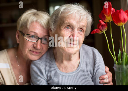 Donna seduta con la sua anziana madre. Foto Stock