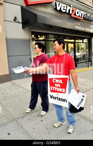 New York City: due telefono Verizon lavoratori distribuendo volantini mentre Picchetti di fronte a Verizon Wireless store Foto Stock