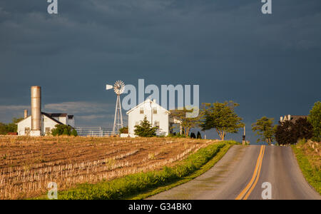 Bianco fattoria paesaggio con un cielo tempestoso nella campagna Amish della contea di Lancaster, Pennsylvania rurale, Stati Uniti, Stati Uniti, percorso casa di campagna silo campo Foto Stock