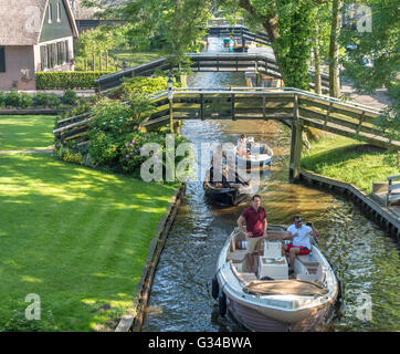 Giethoorn, Paesi Bassi. Barche in Dorpsgracht o canale di villaggio con case coloniche convertito su isole con ponti di privato. Foto Stock