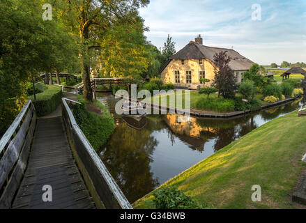 Giethoorn, Paesi Bassi. Barca in Dorpsgracht o villaggio Canal con fattoria convertita sull isola con ponte privato. Foto Stock