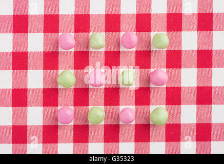 Candy su un rosso e bianco tovaglia a scacchi Foto Stock