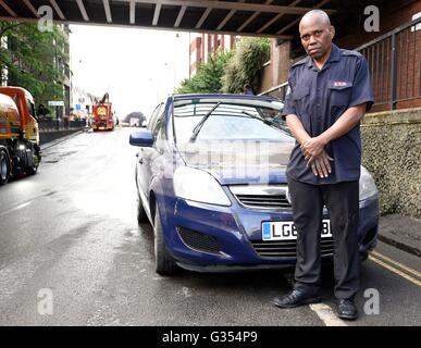 Imoh Darlington, 60, davanti al suo danneggiato Vauxhall Zafira che divenne immerso in acqua durante una inondazione a Manor Road in Wallington, Surrey dopo una pioggia torrenziale. Foto Stock