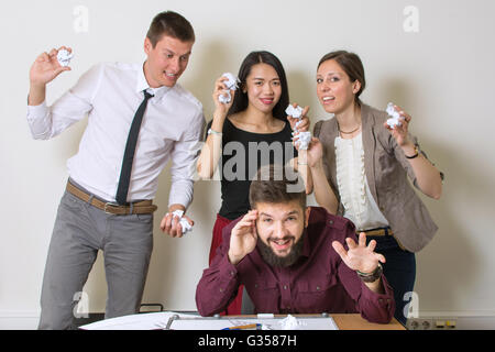 Persone che lanciano sui documenti di un collega in ufficio Foto Stock