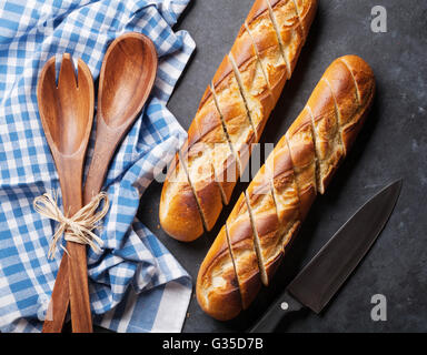 Fette di pane e il coltello sulla pietra scura tabella. Vista da sopra Foto Stock