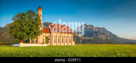 Vista panoramica della famosa cattedrale di San Coloman chiesa vicino a Fussen in golden luce della sera al tramonto in estate, Schwangau, Baviera, Germania Foto Stock