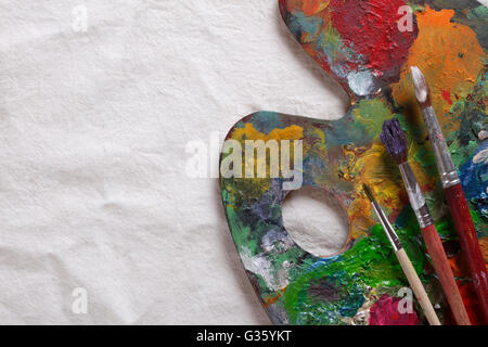 Vecchio usato artista tavolozza con spazzole Foto Stock