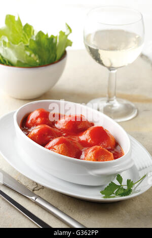 Polpette di pesce coperto con salsa di pomodoro in un piatto bianco. Foto Stock