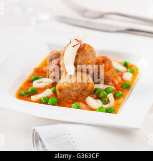 Le polpette di carne in salsa di pomodoro, calamari e piselli verdi Foto Stock