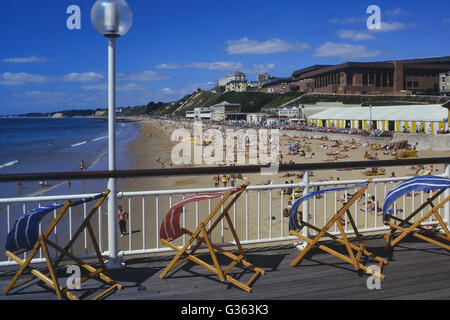 Sedie a sdraio al vento sul molo di Bournemouth. Il Dorset. In Inghilterra. Regno Unito Foto Stock