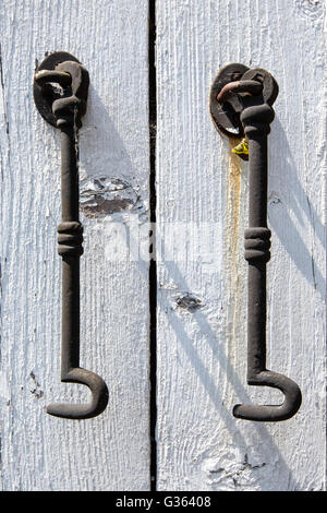 Due ganci di acciaio appeso a un dipinto di bianco in legno del telaio della porta in stretta fino Foto Stock