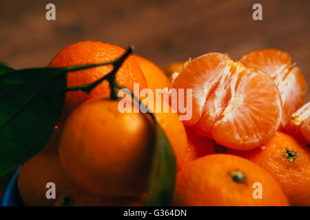 Pelati freschi mandarini sciroppati close up su uno sfondo di colore arancione di mandarini Foto Stock