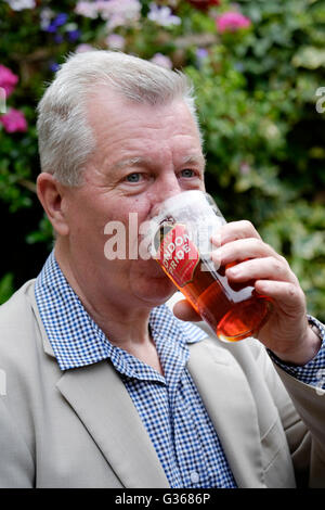 Un maschio in pensione godendo di una pinta di birra in un pub garden England Regno Unito Foto Stock