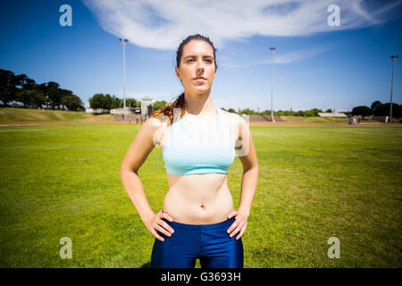 Fiducioso atleta femminile in piedi con la mano sul hip Foto Stock