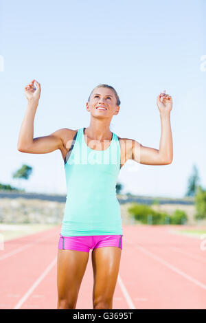 Felice atleta femminile in posa dopo una vittoria Foto Stock