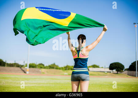 Vista posteriore di atleta femminile tenendo una Bandiera Brasile Foto Stock