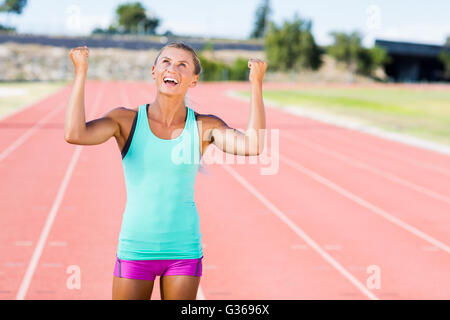 Felice atleta femminile in posa dopo una vittoria Foto Stock