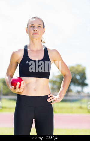 Fiducioso atleta femminile tenendo un colpo messo la sfera Foto Stock