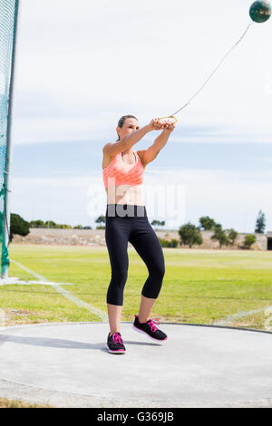 Atleta femminile di eseguire un lancio del martello Foto Stock