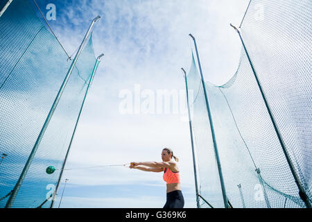 Atleta femminile di eseguire un lancio del martello Foto Stock
