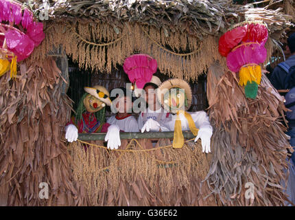 Lucban Filippine. Pahiyas Festival persone che guardano fuori da Windows, decorato per Festival in onore del patrono dei contadini, San Isidore il lavoratore Foto Stock