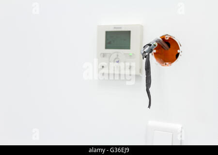 Moderno termostato elettronico digitale, il sistema di controllo del clima in background. Incompiuta elettrico o sistema, uscita presa, spina Foto Stock
