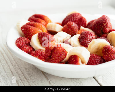 Fragole fresche e fette di banana come fruttato snack. Foto Stock