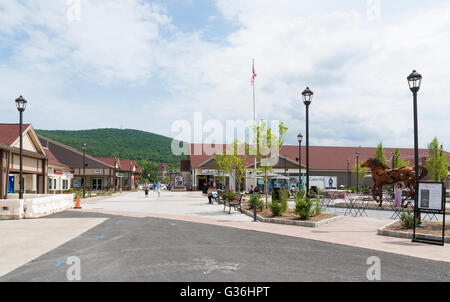 Woodbury Common outlet mall di New York che guarda verso la Calvin Klein designer store e la scultura di un cavallo Foto Stock