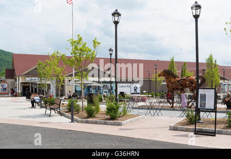 Woodbury Common outlet mall di New York che guarda verso la Calvin Klein designer store e la scultura di un cavallo Foto Stock