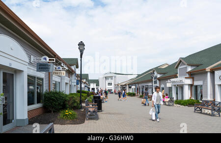 Vista lungo la fila di negozi di design che guarda verso Saks Off quinto al Woodbury Common outlet mall in New York Foto Stock