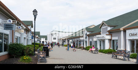 Vista lungo la fila di negozi di design che guarda verso Saks Off quinto al Woodbury Common outlet mall in New York Foto Stock