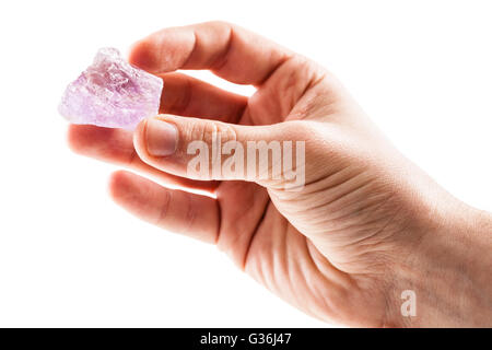 Un maschio di mano che tiene un frammento del minerale di ametista isolato su uno sfondo bianco Foto Stock