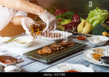 Mano che tiene la bottiglia con liquido. Foto Stock