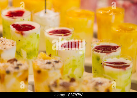Frutta congelata frullati con fresco mescolato diversi tipi di frutta è servita in bicchieri alti, dolce estate trattare Foto Stock