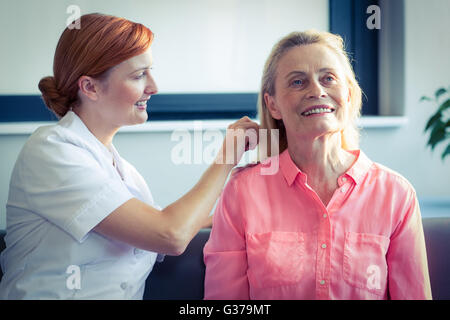 Infermiera femmina pettinare capelli di donna senior Foto Stock